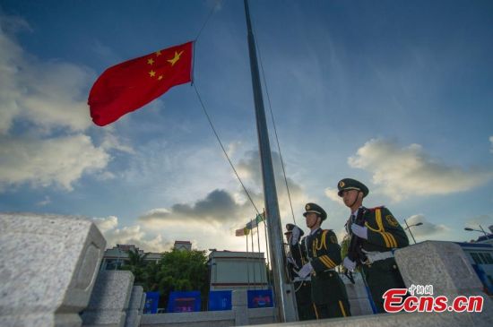 A flag-raising ceremony is held on a square in front of Sansha city government's main building on Yongxing Island, a part of the Xisha Islands, in South China’s Hainan province, July 24, 2015. Nine islands and islets simultaneously held a flag-raising ceremony to celebrate the third anniversary of establishing Sansha city. Sansha, on Yongxing, one of the Xisha islands, was officially established in July in 2012 to administer the Xisha, Zhongsha and Nansha island groups and their surrounding waters in the South China Sea. (Photo: China News Service/Luo Yunfei)