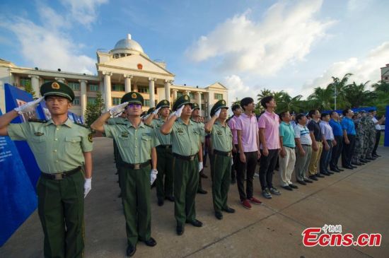 A flag-raising ceremony is held on a square in front of Sansha city government's main building on Yongxing Island, a part of the Xisha Islands, in South China’s Hainan province, July 24, 2015. Nine islands and islets simultaneously held a flag-raising ceremony to celebrate the third anniversary of establishing Sansha city. Sansha, on Yongxing, one of the Xisha islands, was officially established in July in 2012 to administer the Xisha, Zhongsha and Nansha island groups and their surrounding waters in the South China Sea. (Photo: China News Service/Luo Yunfei)